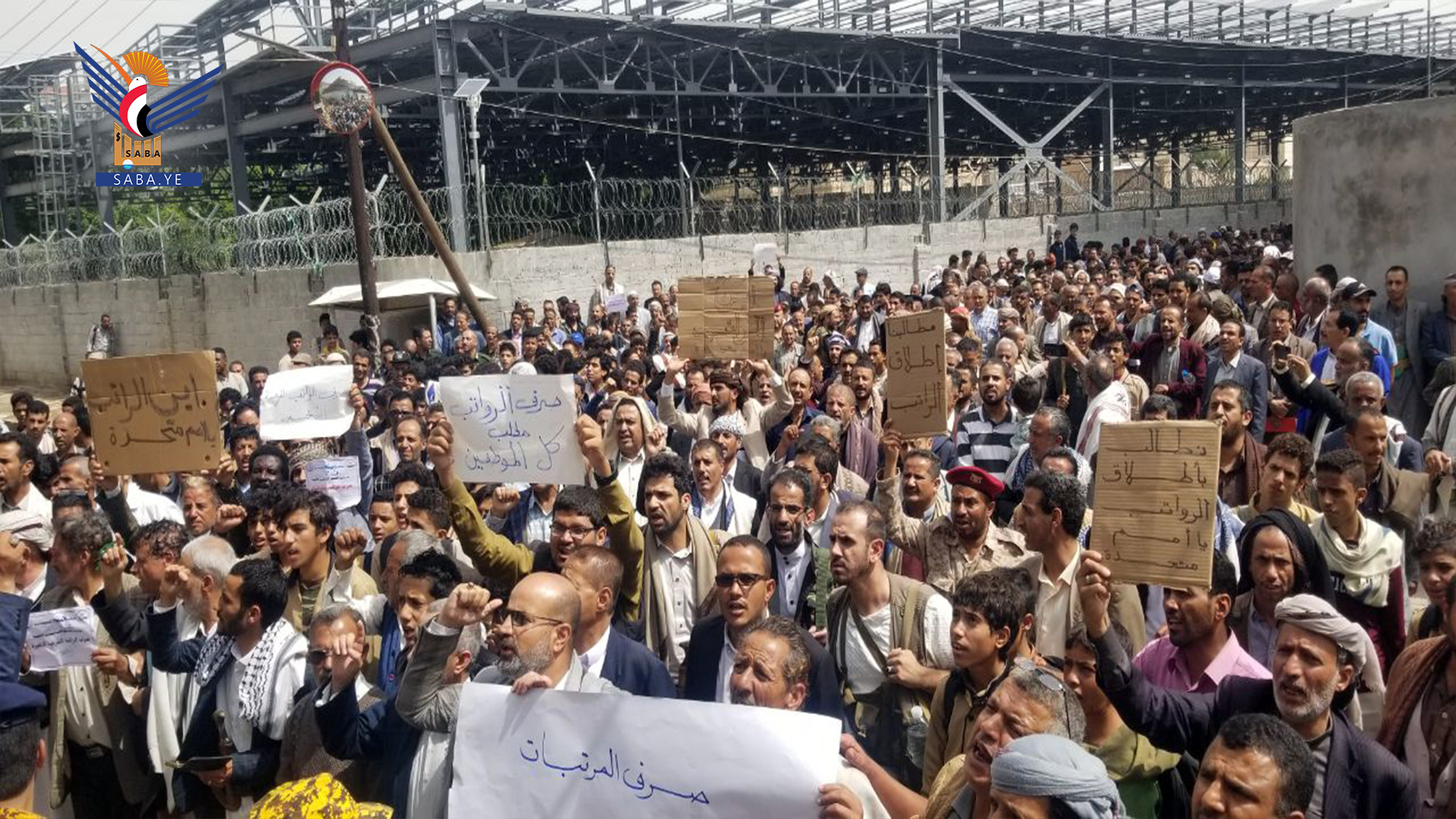 Stand les employés de l'État devant le bureau des Nations Unies à Sanaa exigeant le paiement des salaires